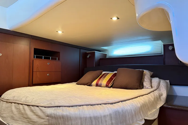 Slide: The Image of The 2014 Meridian 441 Sedan cabin features a cozy bed with pillows and wooden cabinetry. - 31