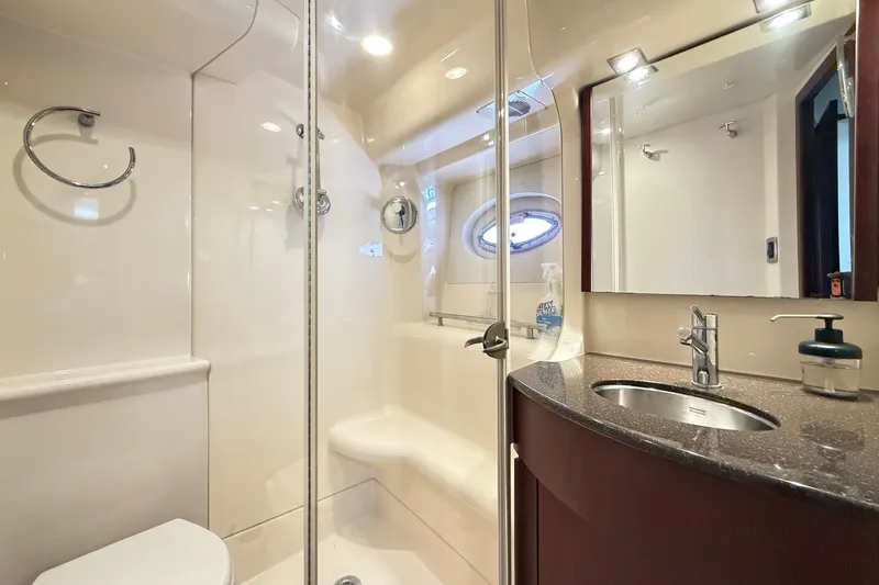 Slide: The Image of The image shows a sleek boat bathroom with a shower, sink, and porthole. - 28