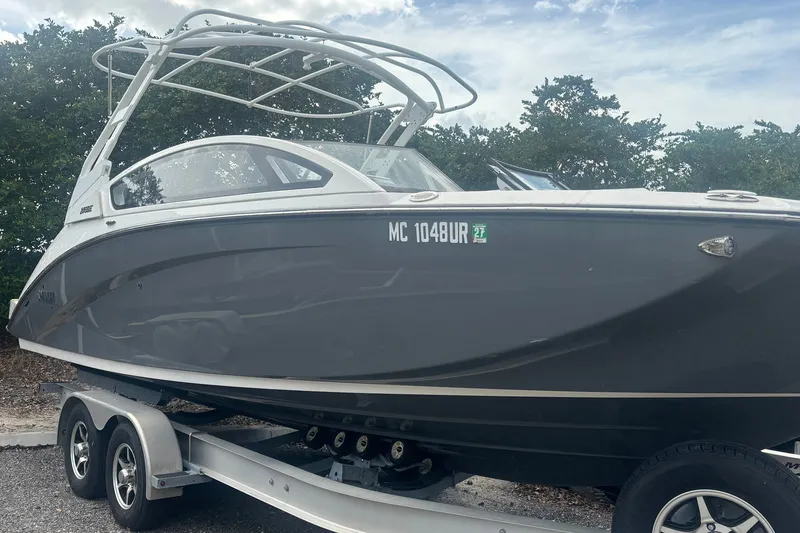 Slide: The Image of 2021 Yamaha Boats 275SE on trailer, sleek design, parked outdoors. - 14