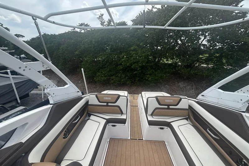Slide: The Image of 2021 Yamaha Boats 275SE interior with cushioned seating and sleek design. - 9