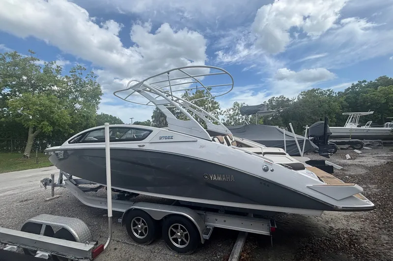 Slide: The Image of 2021 Yamaha Boats 275SE on trailer, parked outdoors under a cloudy sky. - 3