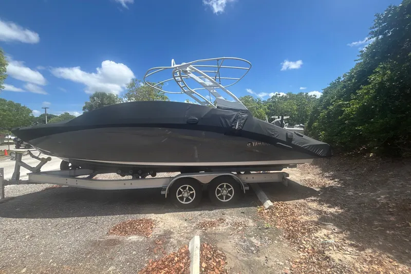 Slide: The Image of 2021 Yamaha Boats 275SE on trailer, covered, under clear blue sky. - 17