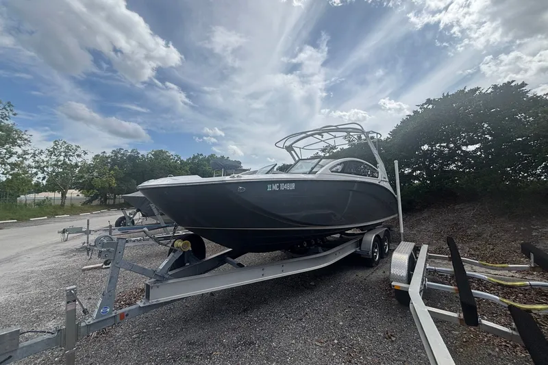 Slide: The Image of 2021 Yamaha Boats 275SE on trailer under cloudy sky, parked outdoors. - 4