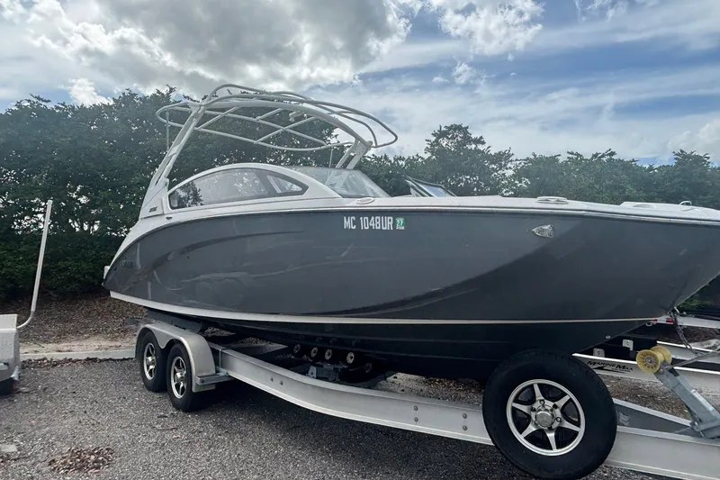 Slide: The Image of 2021 Yamaha Boats 275SE on trailer, parked outdoors under cloudy sky. - 15