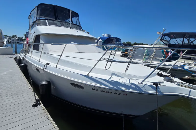 Slide: The Image of 1998 Carver 370 Voyager yacht docked at marina under clear blue sky. - 2