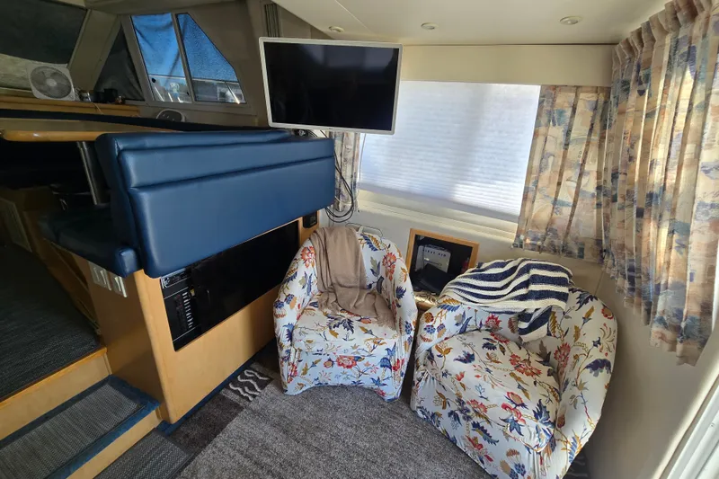Slide: The Image of Interior of 1998 Carver 370 Voyager with floral chairs and mounted TV. - 9