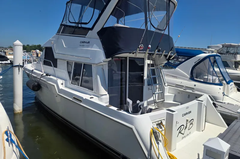 Slide: The Image of 1998 Carver 370 Voyager yacht docked at marina under clear blue sky. - 3