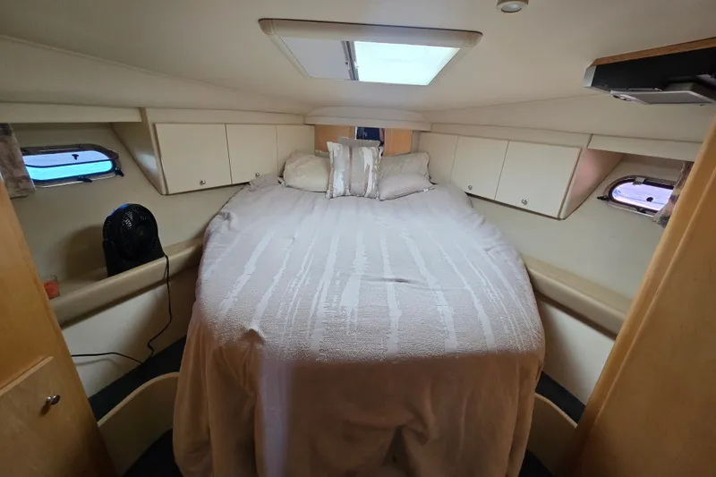 Slide: The Image of Cozy cabin interior of 1998 Carver 370 Voyager with bed and storage cabinets. - 13