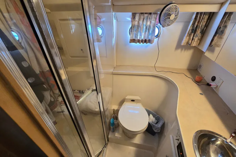 Slide: The Image of Bathroom interior of a 1998 Carver 370 Voyager yacht, featuring a toilet and shower. - 7