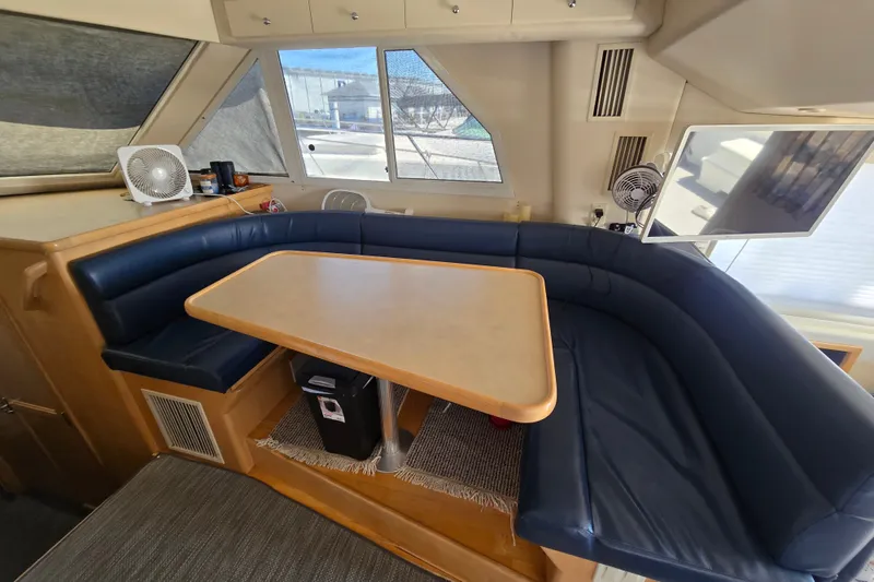 Slide: The Image of Interior of 1998 Carver 370 Voyager yacht with blue seating and dining table. - 6