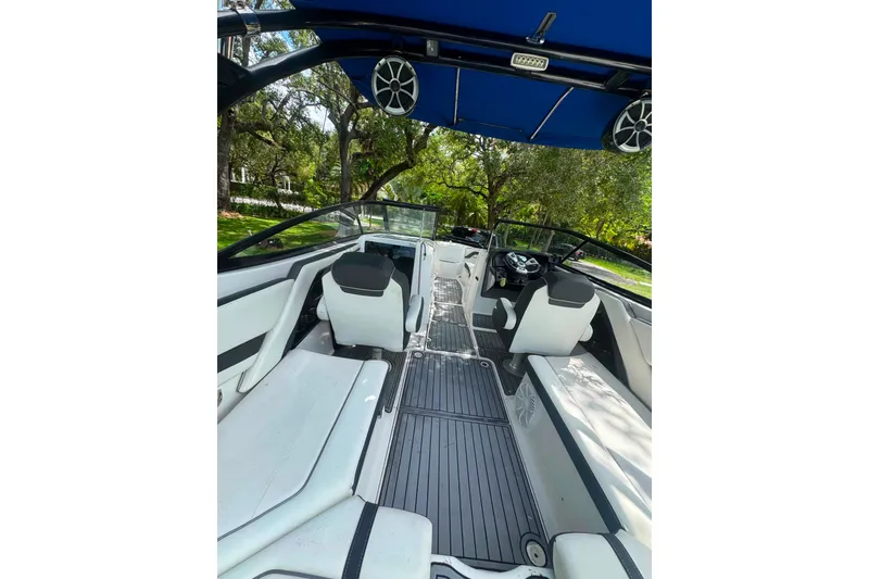 Slide: The Image of 2015 Yamaha Boats AR240 interior with sleek seating and modern dashboard under a blue canopy. - 33