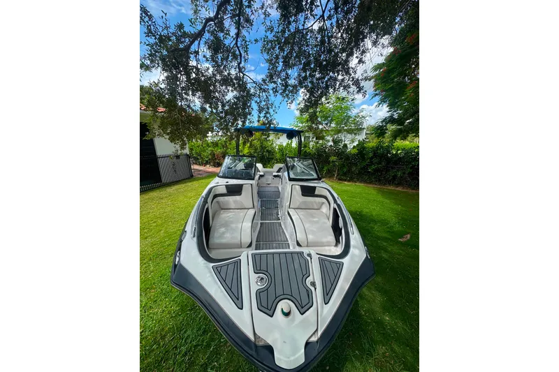 Slide: The Image of 2015 Yamaha Boats AR240 on grass, open interior, surrounded by trees and blue sky. - 10