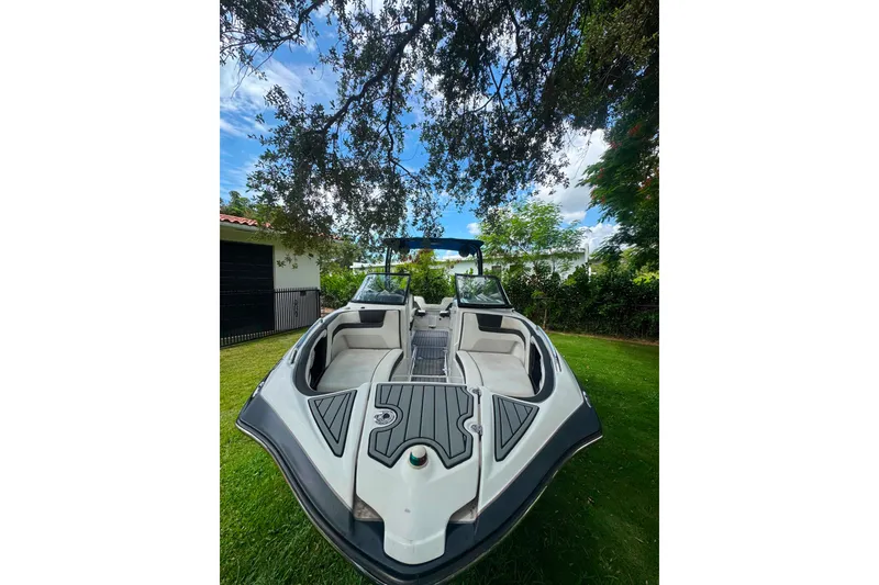 Slide: The Image of 2015 Yamaha Boats AR240 on grass, under tree, with clear sky background. - 11
