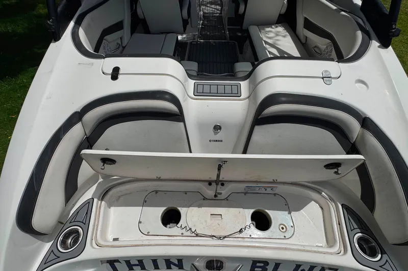 Slide: The Image of 2015 Yamaha Boats AR240 interior with open storage compartment, showcasing seating and design features. - 16