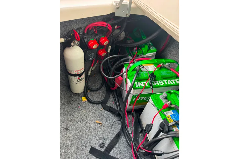Slide: The Image of 2015 Yamaha AR240 boat battery compartment with Interstate batteries and fire extinguisher. - 45