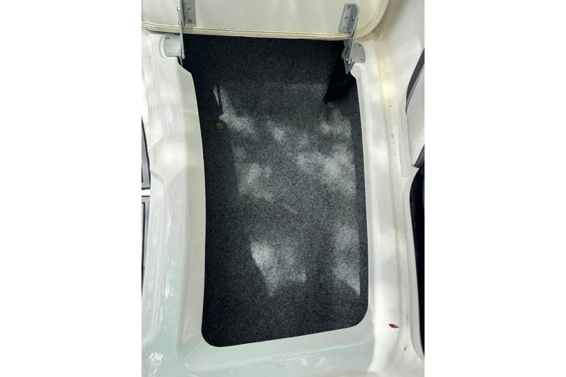 Slide: The Image of Storage compartment of a 2015 Yamaha Boats AR240, featuring a carpeted interior. - 43