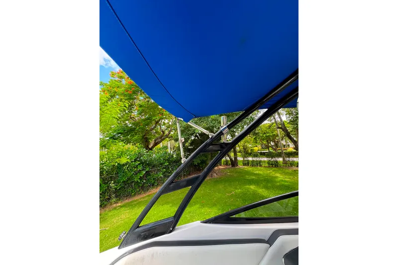 Slide: The Image of 2015 Yamaha AR240 boat with blue canopy and sleek black frame. - 18