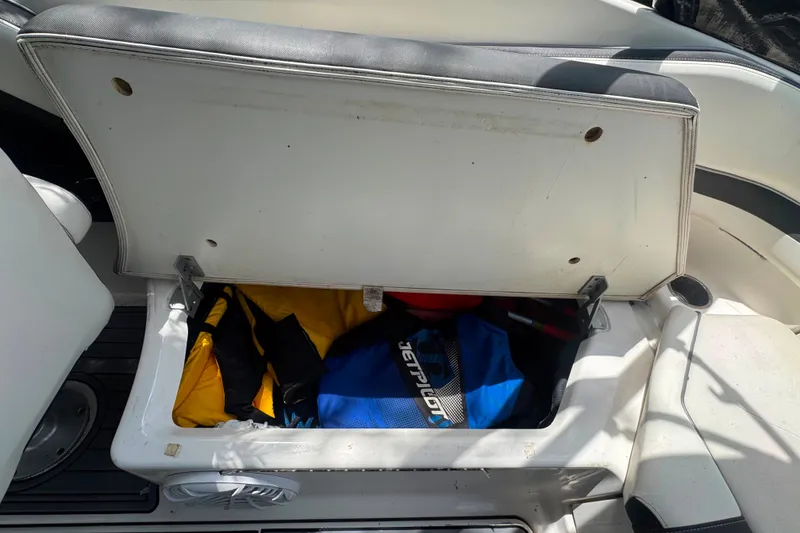 Slide: The Image of Open storage compartment on 2015 Yamaha AR240 boat with life jackets inside. - 46