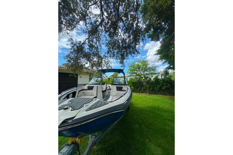 Slide: The Image of 2015 Yamaha Boats AR240 on grass under trees, showcasing sleek design and spacious interior. - 9