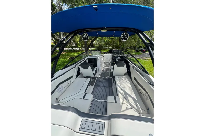 Slide: The Image of 2015 Yamaha Boats AR240 interior with seating, steering, and blue canopy. - 32