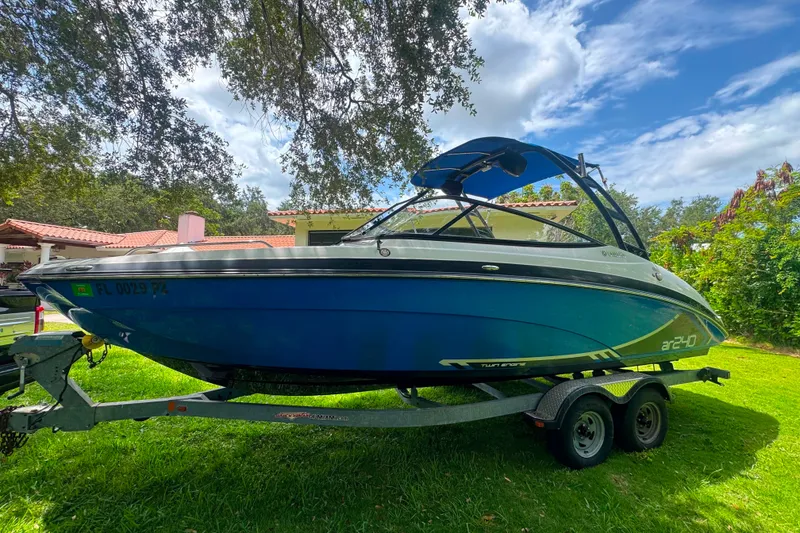 Slide: The Image of 2015 Yamaha AR240 boat on trailer, parked on grass under a tree. - 4