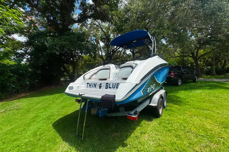 Slide: The Image of 2015 Yamaha Boats AR240 on trailer, parked on grass, surrounded by trees. - 7