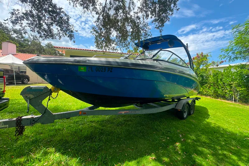 Slide: The Image of 2015 Yamaha Boats AR240 on trailer, parked on grass under a sunny sky. - 6
