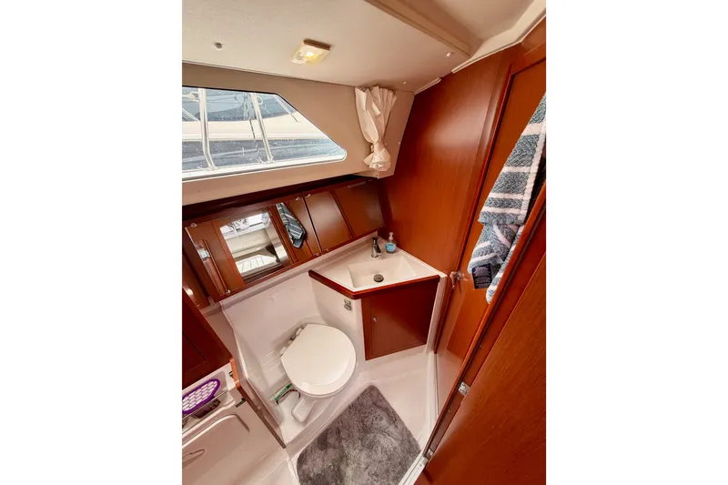 Slide: The Image of 2017 Beneteau Oceanis 41.1 yacht bathroom with wooden cabinetry and modern fixtures. - 76