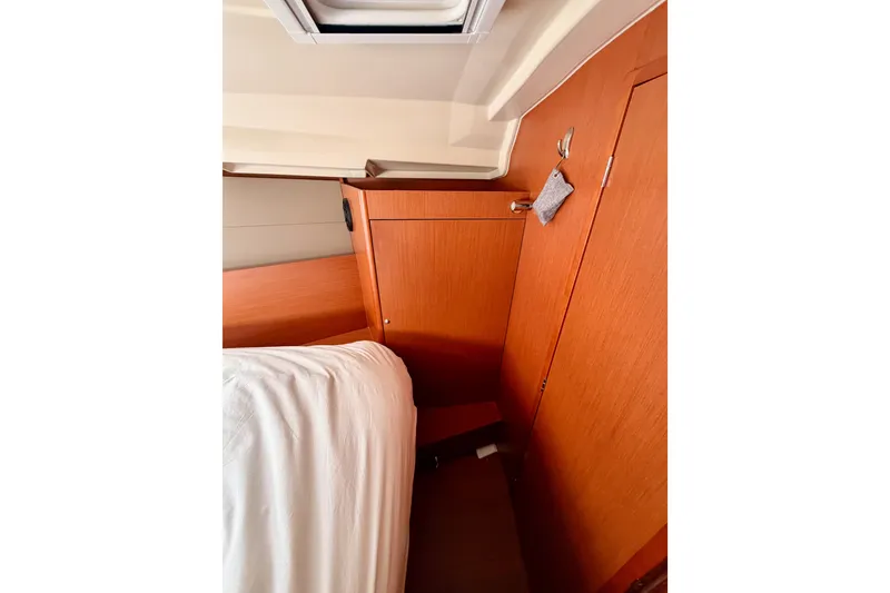 Slide: The Image of Interior cabin of 2017 Beneteau Oceanis 41.1 yacht with wooden cabinetry and bedding. - 100