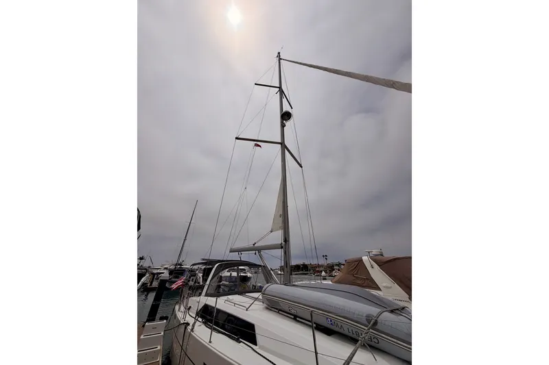 Slide: The Image of 2017 Beneteau Oceanis 41.1 sailboat docked under cloudy sky, showcasing tall mast and sleek design. - 9