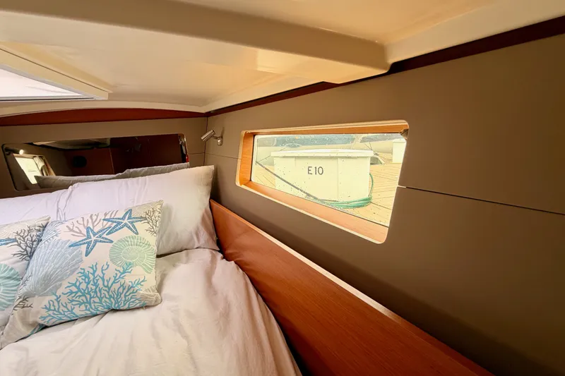 Slide: The Image of Cozy cabin interior of 2017 Beneteau Oceanis 41.1 with nautical-themed pillows and window view. - 102
