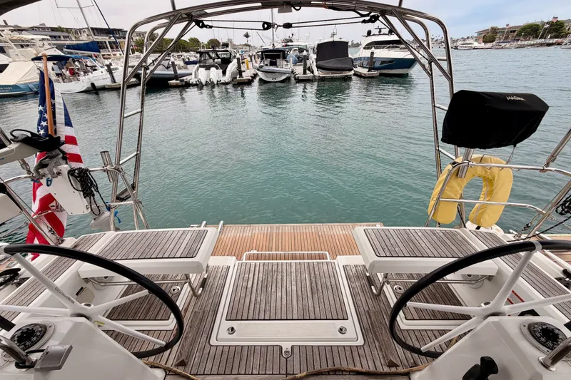 Slide: The Image of 2017 Beneteau Oceanis 41.1 yacht docked at marina, showcasing elegant deck and steering wheels. - 30
