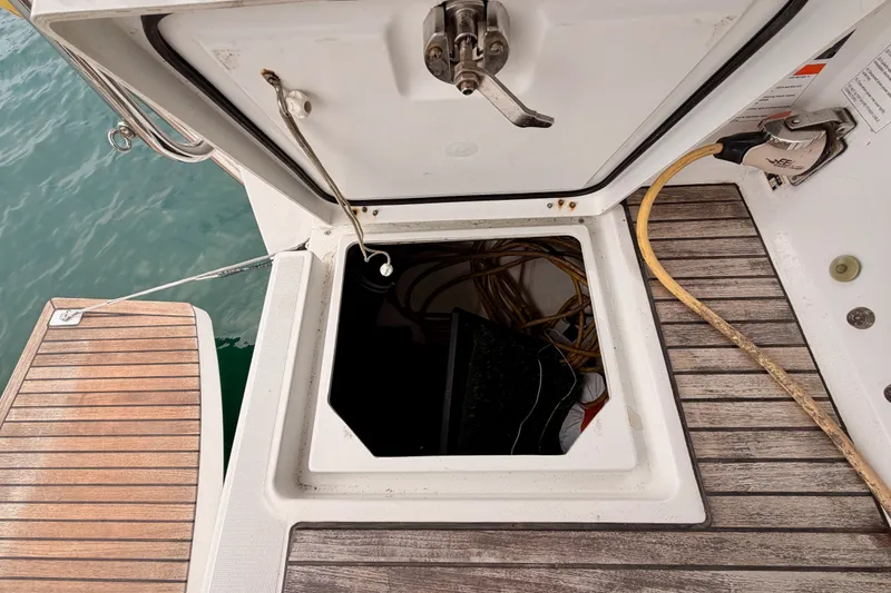 Slide: The Image of Open hatch on 2017 Beneteau Oceanis 41.1 sailboat, revealing storage compartment and cables. - 49
