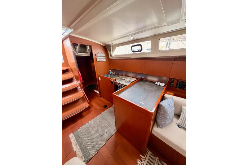 Slide: The Image of Interior of 2017 Beneteau Oceanis 41.1 yacht, featuring a cozy kitchen and seating area. - 61