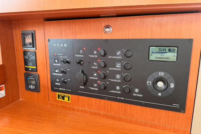 Slide: The Image of Control panel of a 2017 Beneteau Oceanis 41.1 yacht, featuring various switches and a digital display. - 91