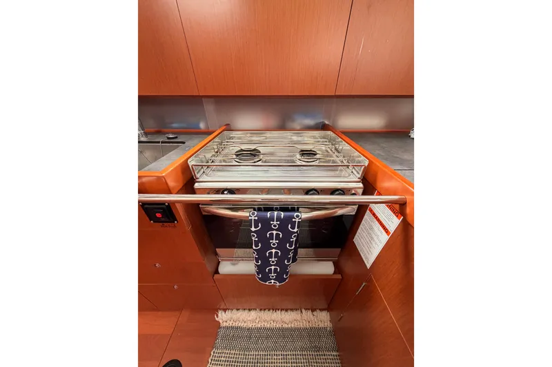 Slide: The Image of Galley kitchen in 2017 Beneteau Oceanis 41.1 yacht with stove and wooden cabinetry. - 64