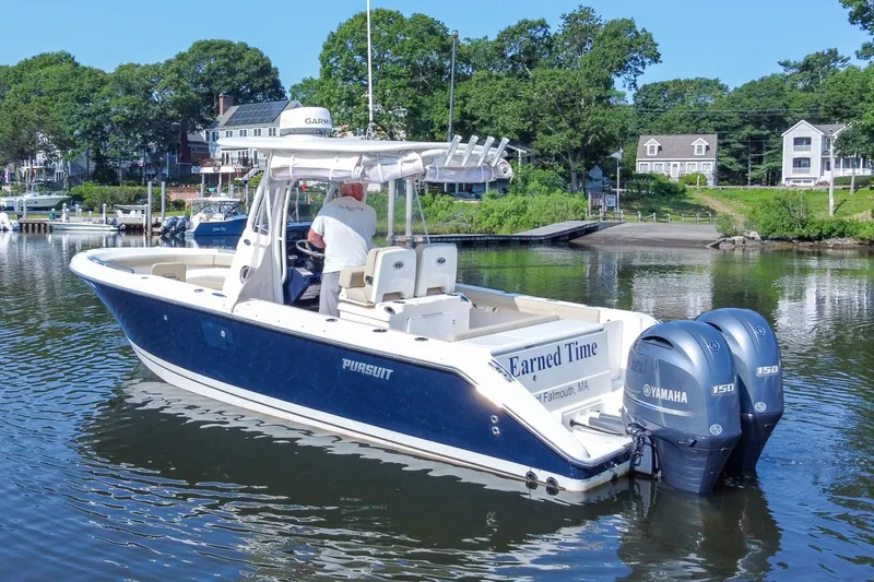 Slide: The Image of 2018 Pursuit C 260 Center Console boat on calm water near shoreline homes. - 5