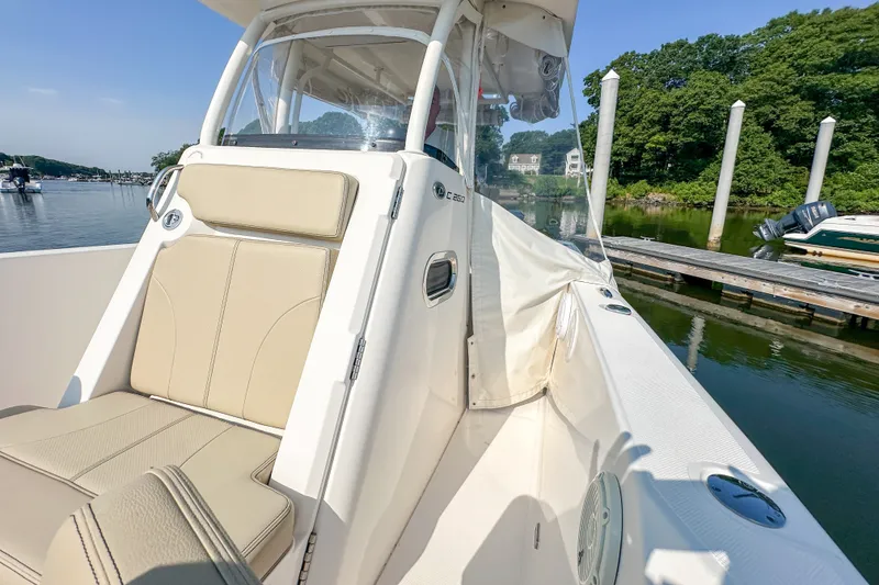 Slide: The Image of 2018 Pursuit C 260 Center Console boat docked by a serene waterfront. - 40