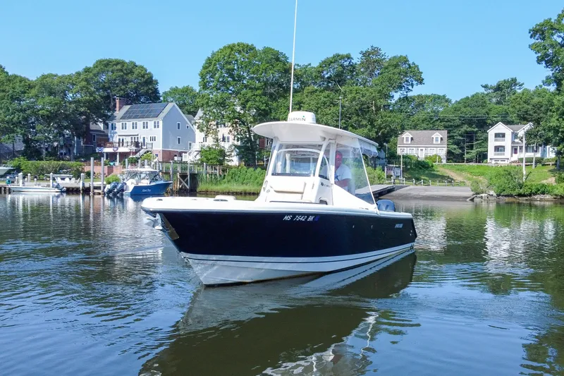 Slide: The Image of 2018 Pursuit C 260 Center Console boat on calm water near residential area. - 3