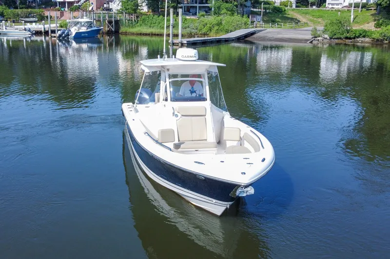 Slide: The Image of 2018 Pursuit C 260 Center Console boat on calm water near a dock. - 16