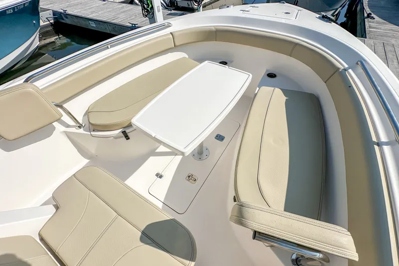 Slide: The Image of 2018 Pursuit C 260 Center Console boat interior with beige seating and a white table. - 37