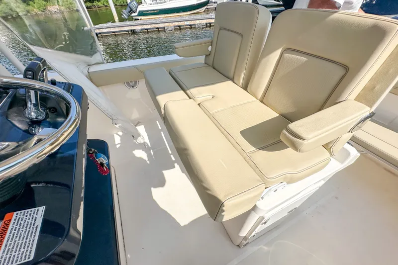 Slide: The Image of 2018 Pursuit C 260 Center Console boat with beige seating and steering wheel detail. - 32