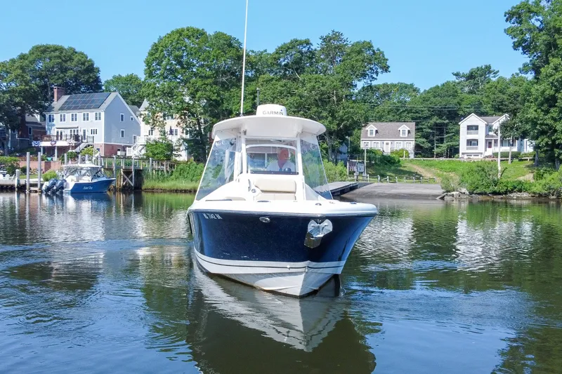 Slide: The Image of 2018 Pursuit C 260 Center Console boat on calm water near residential area. - 2
