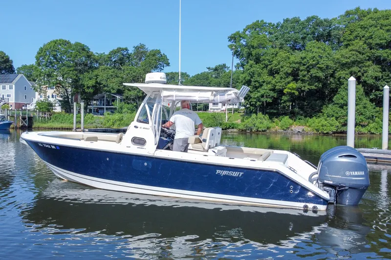 Slide: The Image of 2018 Pursuit C 260 Center Console boat on calm water near a dock. - 6
