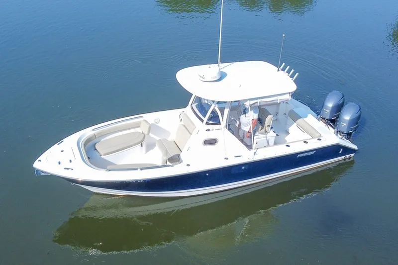 Slide: The Image of 2018 Pursuit C 260 Center Console boat on calm water, featuring dual engines. - 19