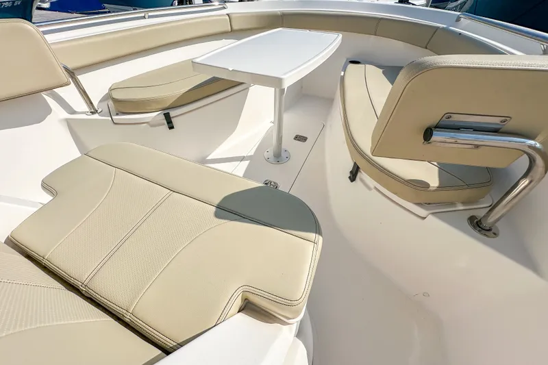 Slide: The Image of 2018 Pursuit C 260 Center Console boat interior with beige seating and table. - 36