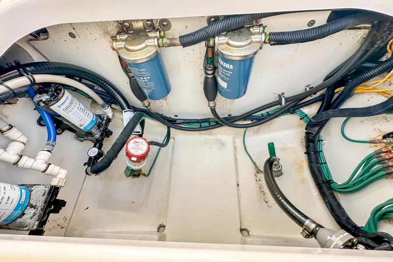 Slide: The Image of Engine compartment of a 2018 Pursuit C 260 Center Console with visible filters and wiring. - 55