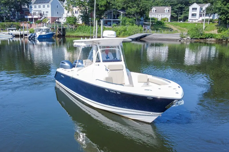 Slide: The Image of 2018 Pursuit C 260 Center Console boat on calm water near a dock. - 15
