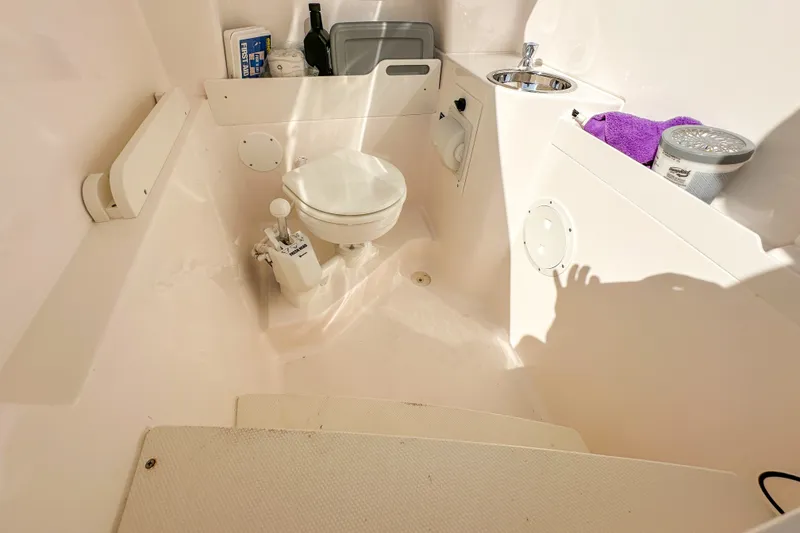 Slide: The Image of 2018 Pursuit C 260 Center Console boat interior with toilet and sink. - 52