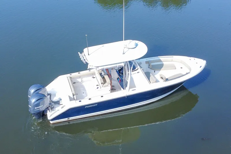 Slide: The Image of 2018 Pursuit C 260 Center Console boat on calm water, featuring dual Yamaha engines. - 25